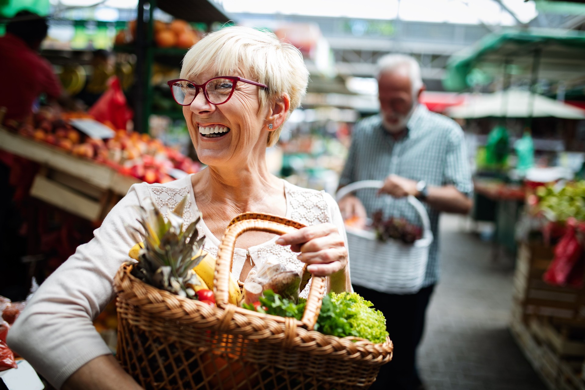 Senior couple buying fresh vegetables and fruits at the local market